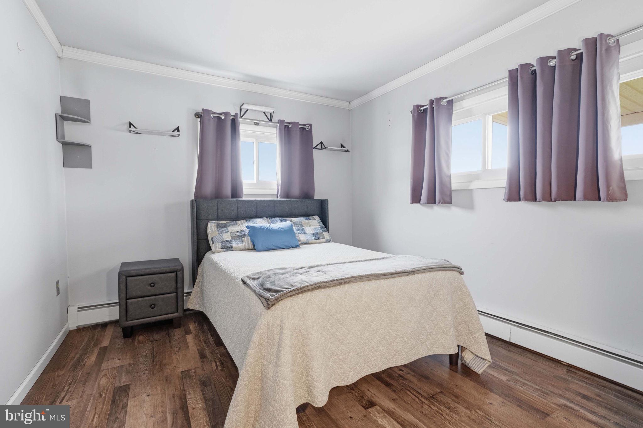 396 Pinewood Drive Levittown, PA 19054 - Photo 24 of 32 a bedroom with a bed and wooden floor
