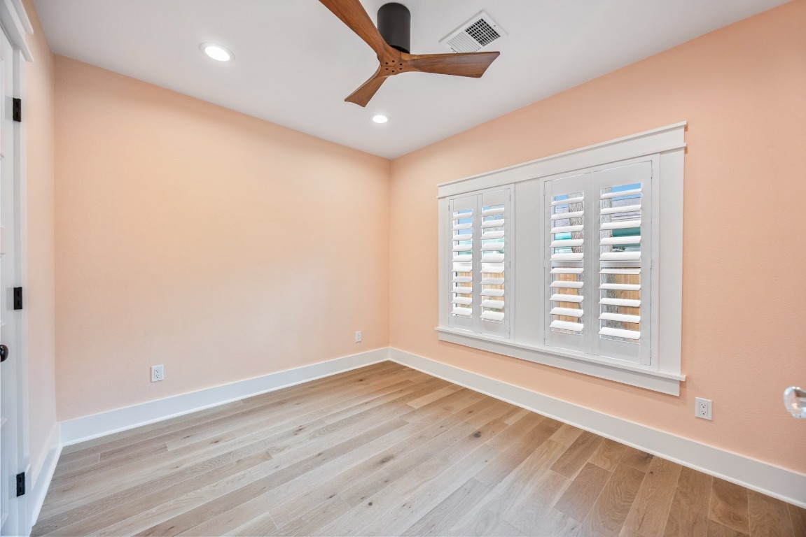 1104 Walton Street Houston, TX 77009 - Photo 13 of 27 Bright peach walls and stylish finishes make this downstairs bedroom a cheerful retreat.
