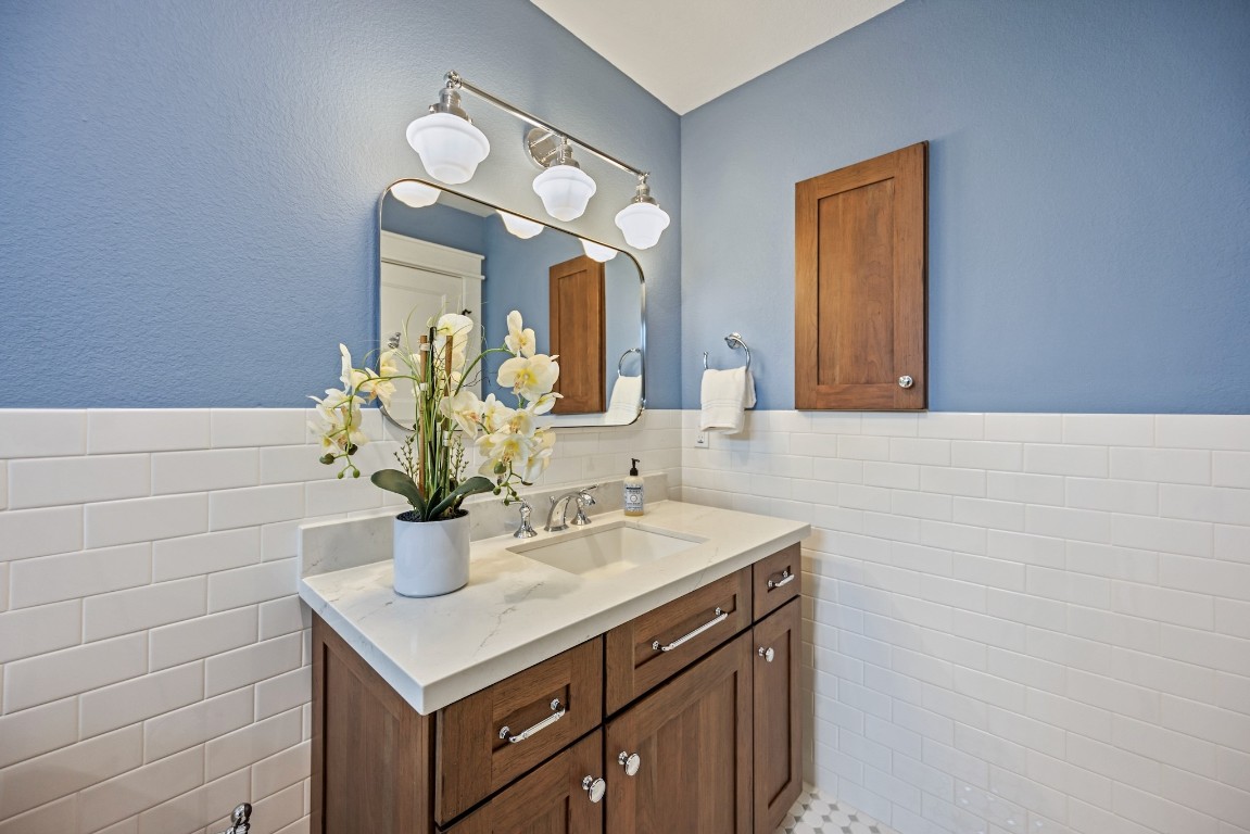 1104 Walton Street Houston, TX 77009 - Photo 15 of 27 The vanity, accented by an attractive mirror and a medicine cabinet, maximizes space and style, complete with a pocket door for privacy when stepping out of the adjacent bedroom.