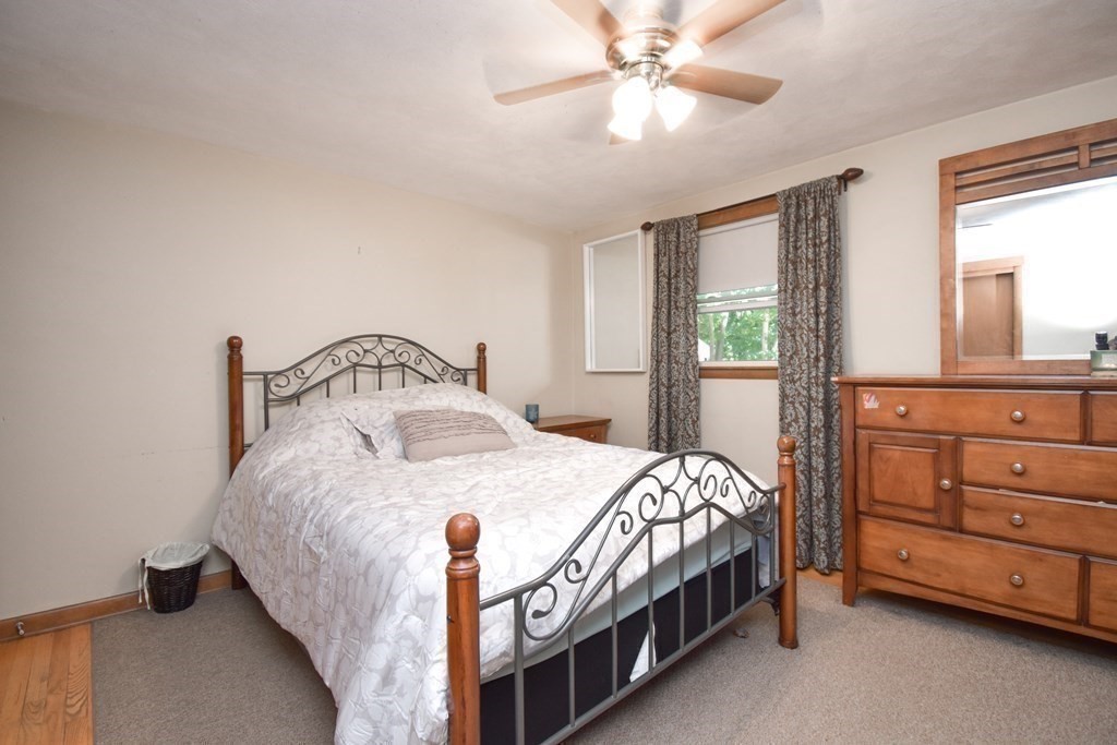 128 Tioga Street Springfield, MA 01128 - Photo 14 of 33 a bedroom with a bed a chandelier and a dresser