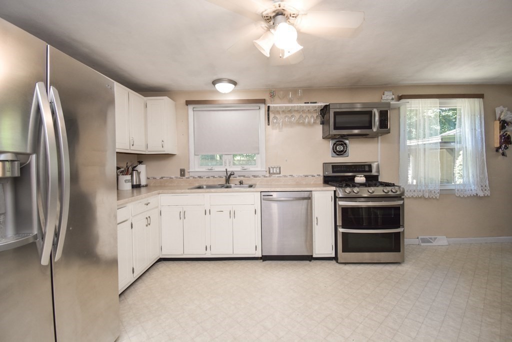 128 Tioga Street Springfield, MA 01128 - Photo 6 of 33 a kitchen with stainless steel appliances a stove a sink and a refrigerator