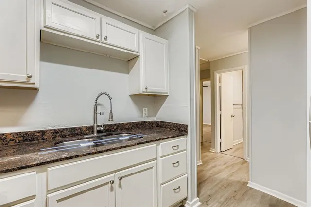 a kitchen with granite countertop a sink and a stove