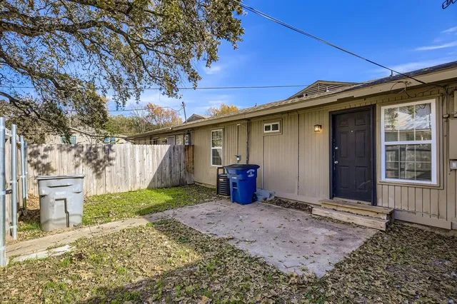 a view of a house with a small yard and wooden fence