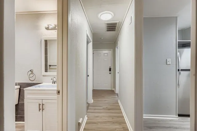 a view of a hallway with wooden floor