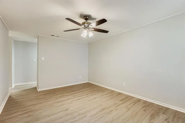a view of an empty room with wooden floor