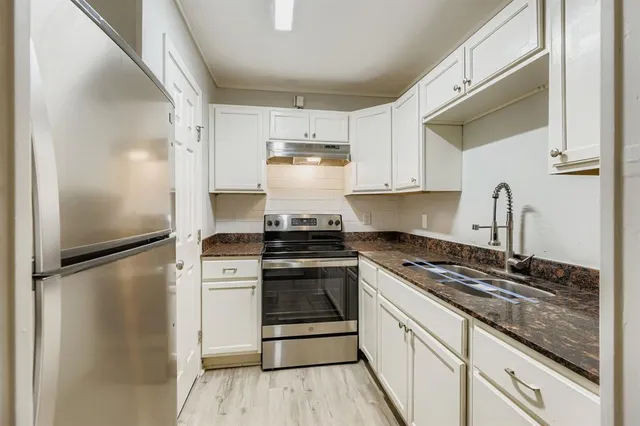 a kitchen with a refrigerator stove and cabinets