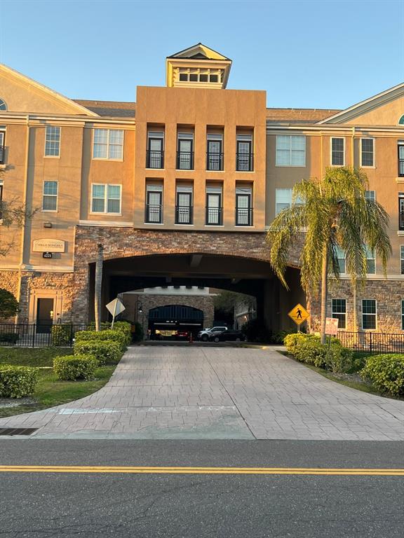 a front view of a building with a garden and plants