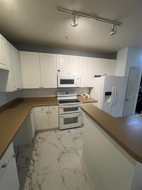 4221 West Spruce Street, Unit 2222 Tampa, FL 33607 - Photo 15 of 25 a kitchen with granite countertop a refrigerator and a stove top oven