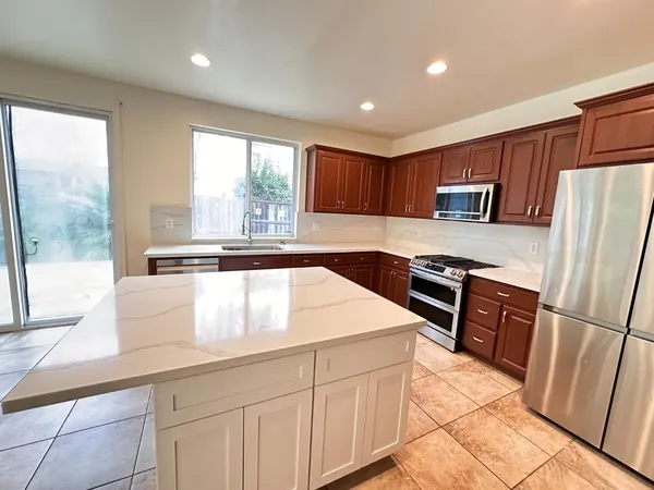 a kitchen with stainless steel appliances granite countertop a stove a sink and a refrigerator