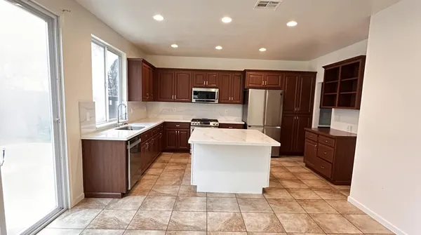 a kitchen with granite countertop wooden cabinets and stainless steel appliances