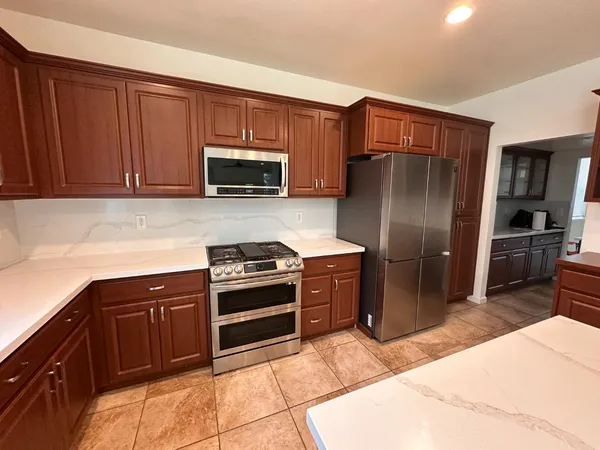a kitchen with stainless steel appliances a stove a microwave and a refrigerator
