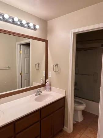 a bathroom with a granite countertop sink toilet and shower