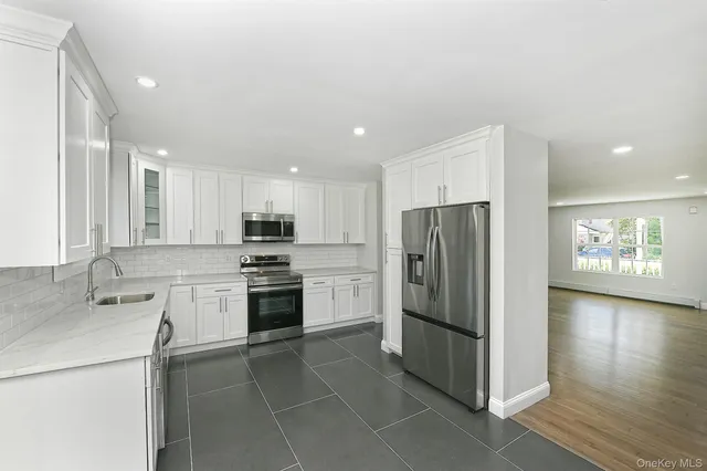 a kitchen with stainless steel appliances granite countertop a refrigerator and a stove top oven