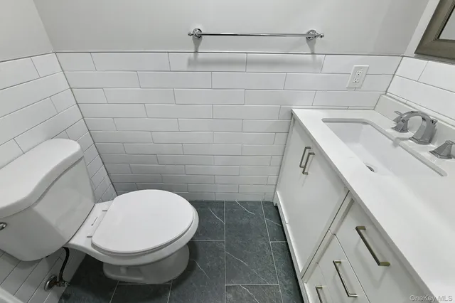 a open kitchen with granite countertop a stove top oven a sink dishwasher a dining table and chairs with wooden floor