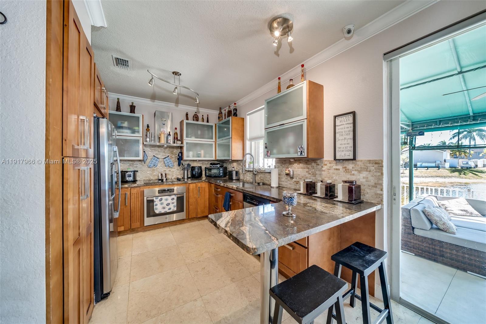15242 Southwest 8th Way Miami, FL 33194 - Photo 18 of 62 a kitchen with stainless steel appliances granite countertop a sink and cabinets