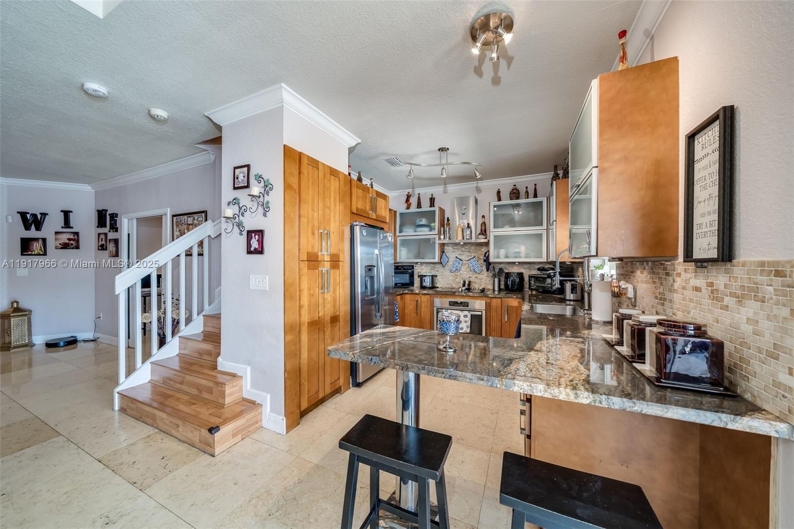 15242 Southwest 8th Way Miami, FL 33194 - Photo 20 of 62 a kitchen with stainless steel appliances granite countertop a refrigerator a sink dishwasher a dining table and chairs with wooden floor