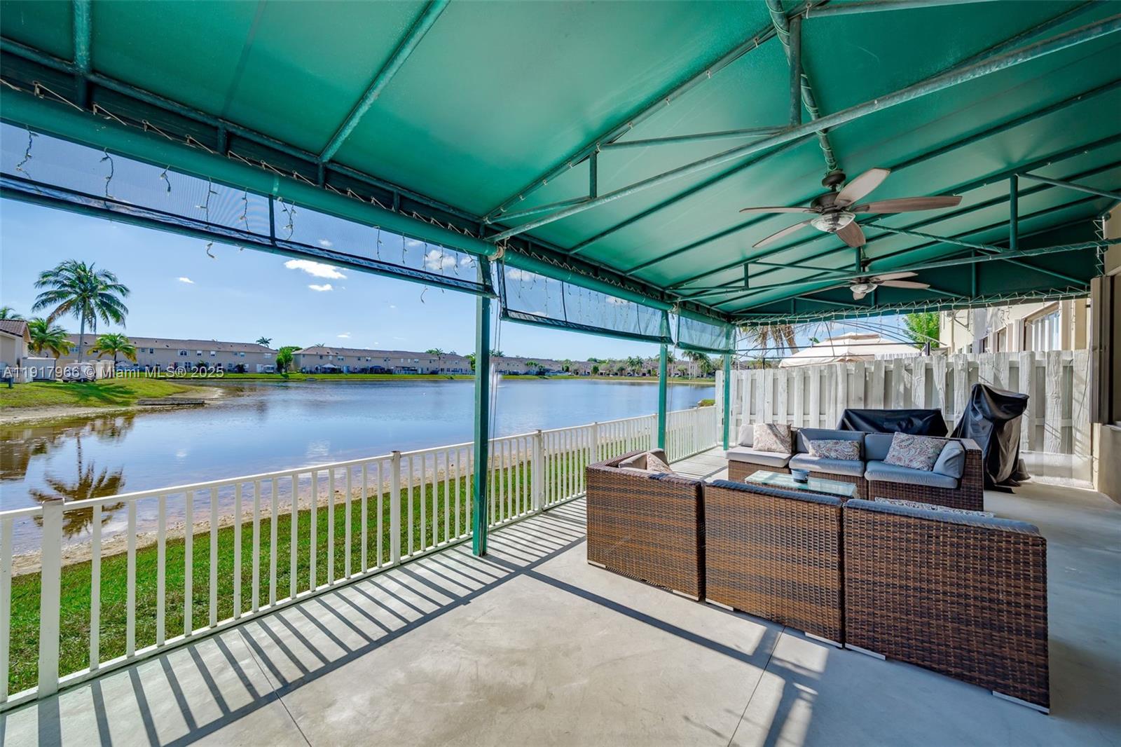 15242 Southwest 8th Way Miami, FL 33194 - Photo 38 of 62 a view of a lake with couches under an umbrella