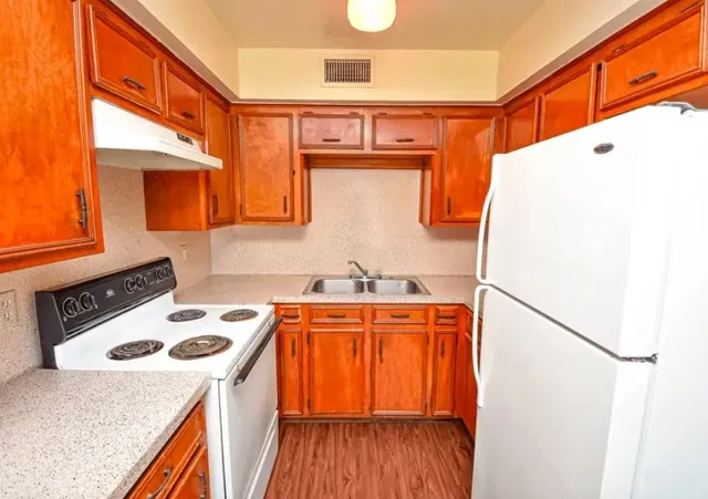 a kitchen with a stove a refrigerator and a stove top oven