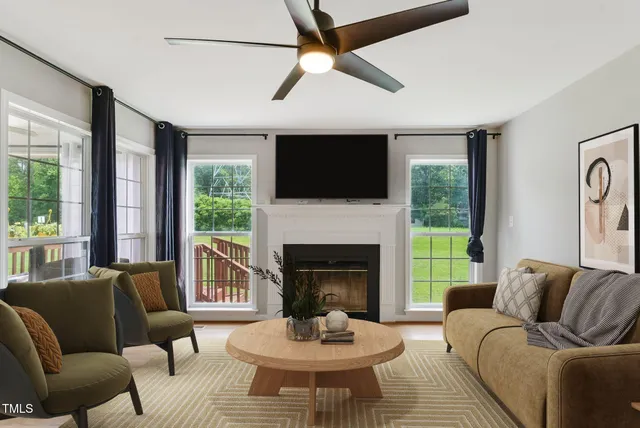 a living room with furniture fireplace and a large window