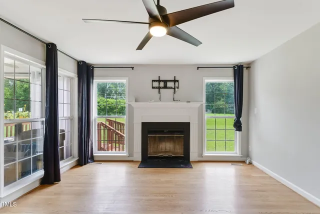 a view of an empty room with a fireplace and a window
