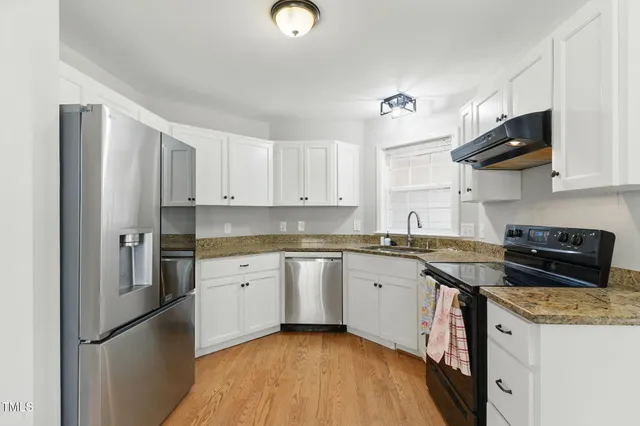 a kitchen with stainless steel appliances granite countertop a stove a refrigerator and a sink