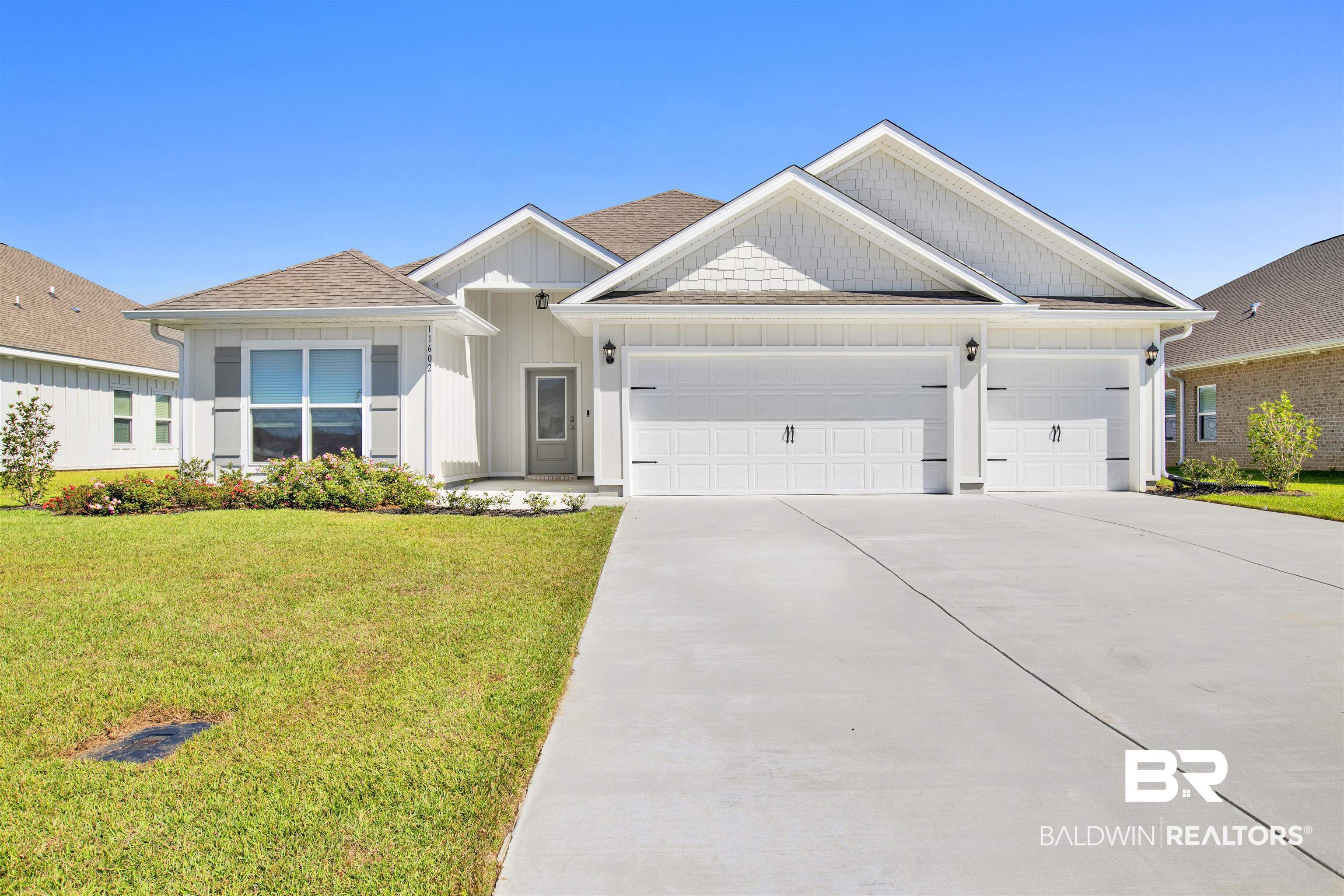 11602 Genuine Risk Circle Daphne, AL 36526 - Photo 1 of 30 View of front of home featuring concrete driveway, an attached garage, a front lawn, and board and batten siding