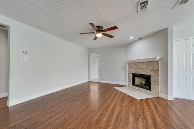 a view of empty room with wooden floor and fireplace