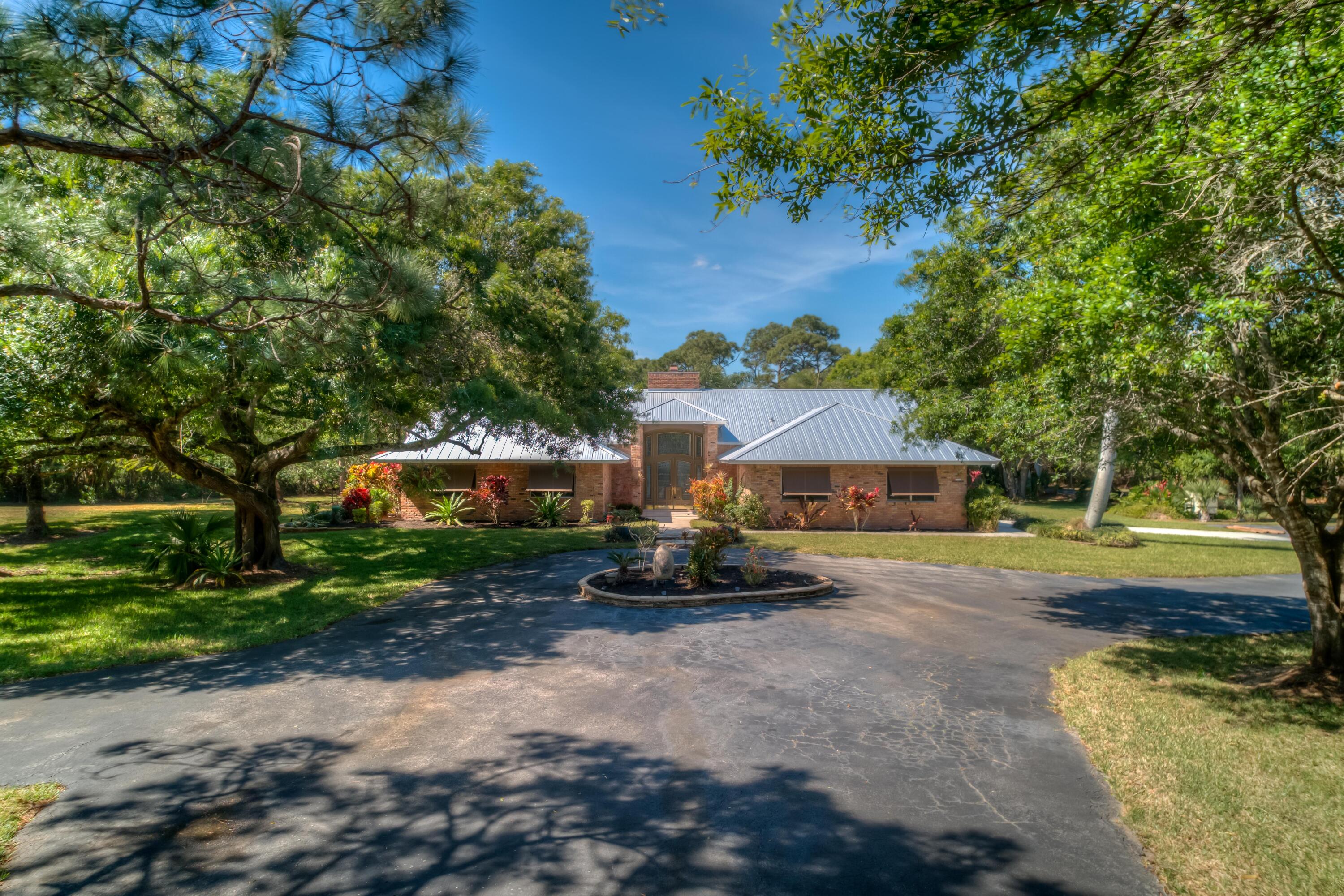 8850 Hidden Pines Road Fort Pierce, FL 34945 - Photo 1 of 72 a front view of a house with a yard and garage
