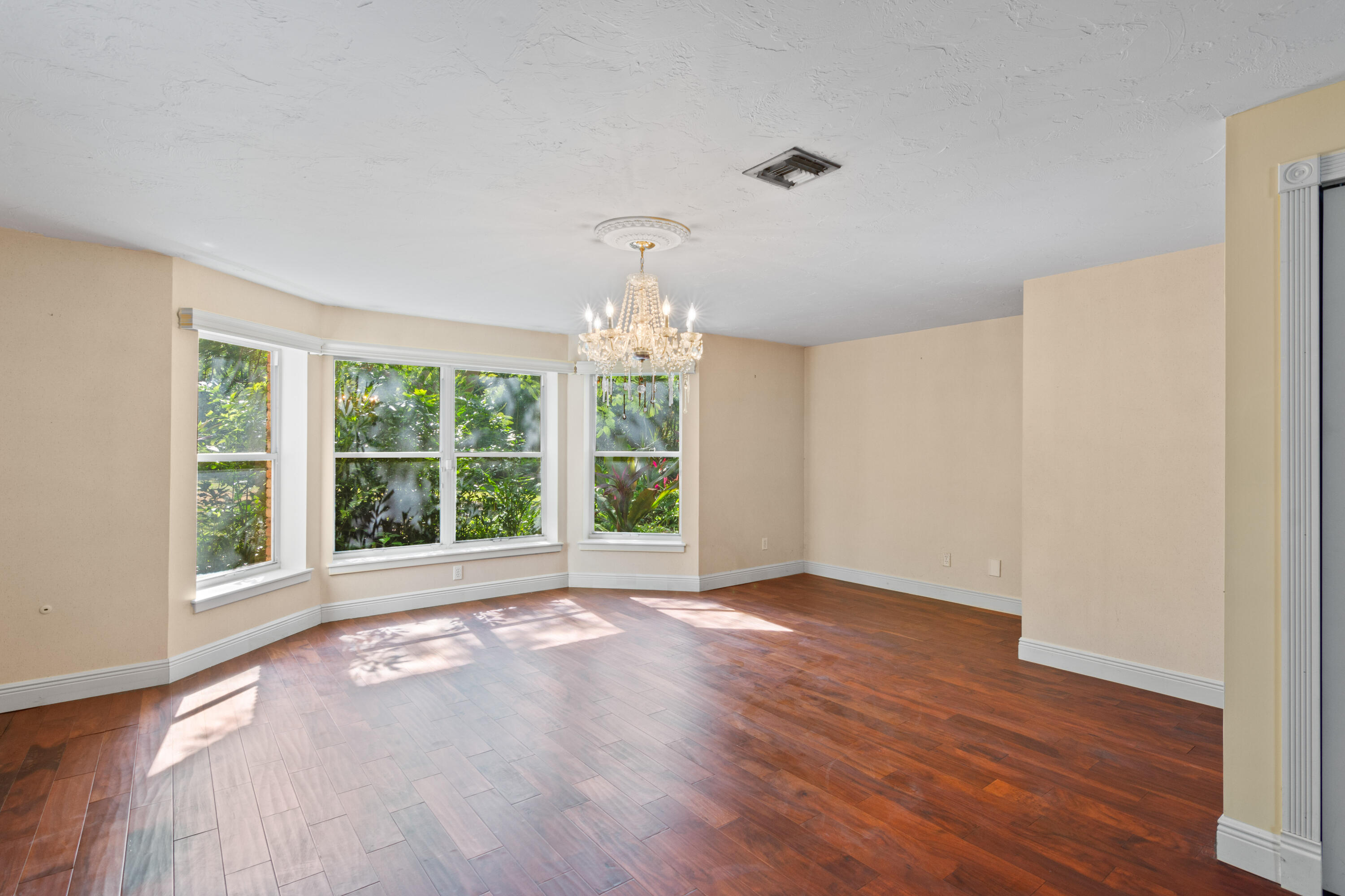 8850 Hidden Pines Road Fort Pierce, FL 34945 - Photo 12 of 72 a view of an empty room with wooden floor and a window