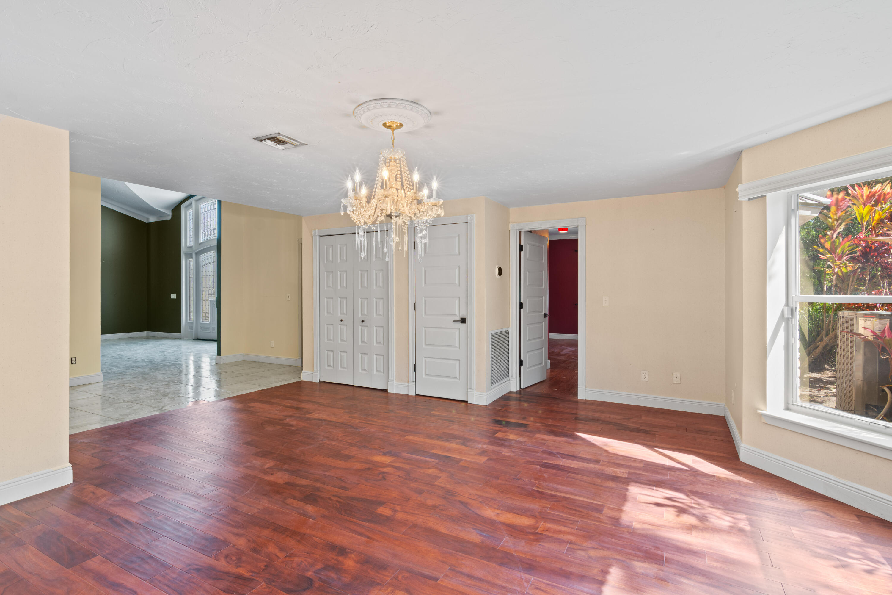 8850 Hidden Pines Road Fort Pierce, FL 34945 - Photo 13 of 72 a view of a hallway with wooden floor and a chandelier