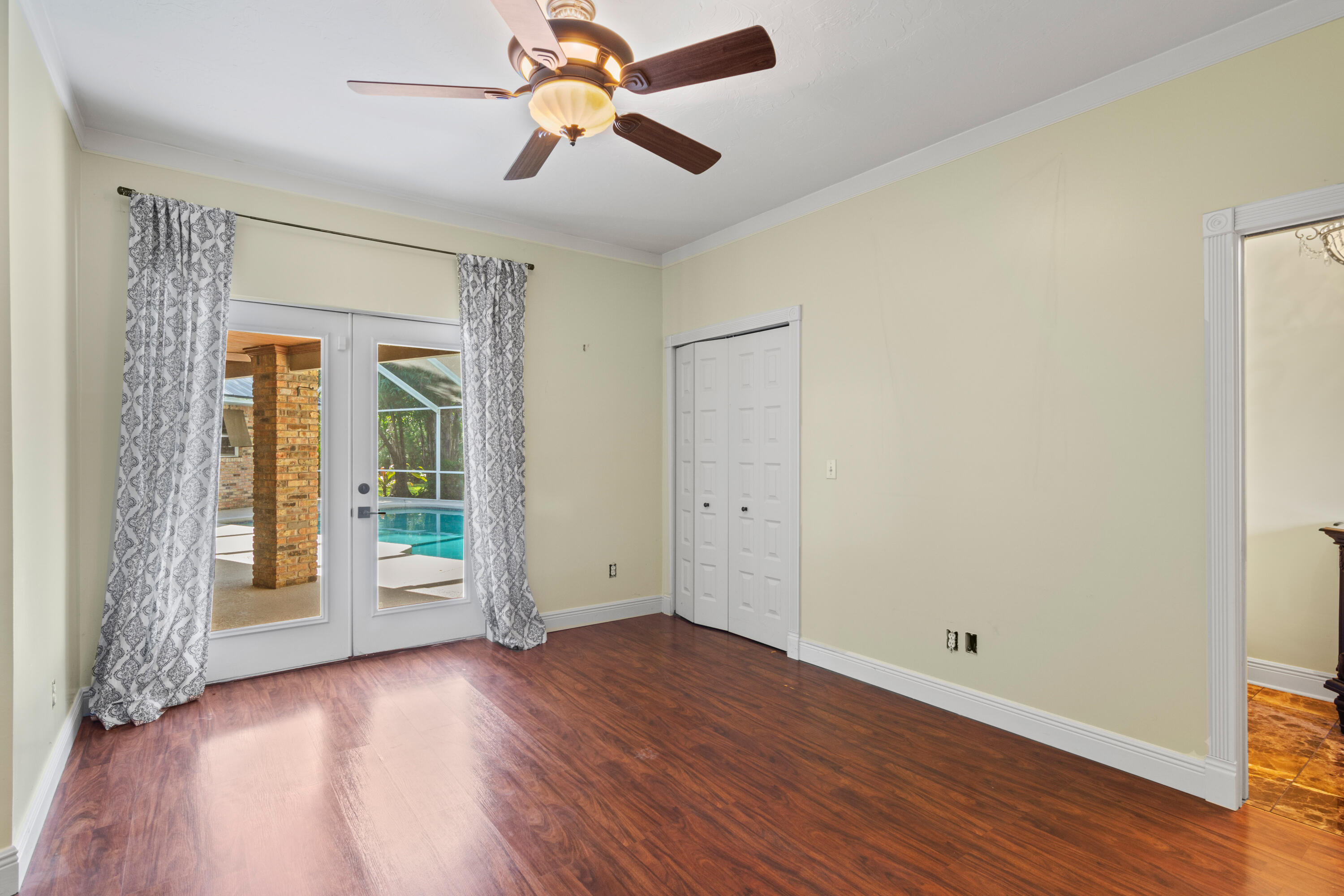 8850 Hidden Pines Road Fort Pierce, FL 34945 - Photo 31 of 72 an empty room with wooden floor fan and windows