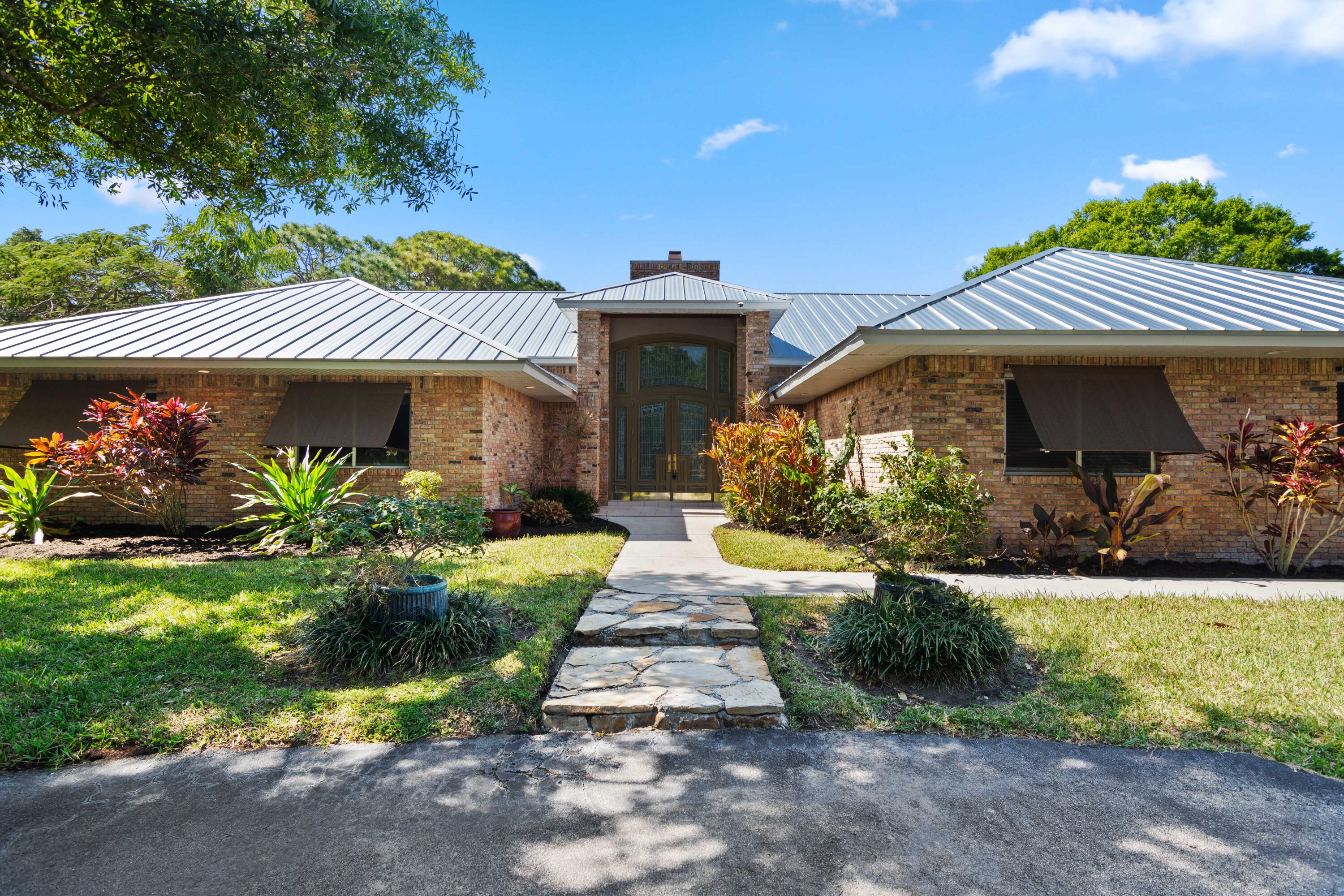 8850 Hidden Pines Road Fort Pierce, FL 34945 - Photo 6 of 72 a front view of a house with garden