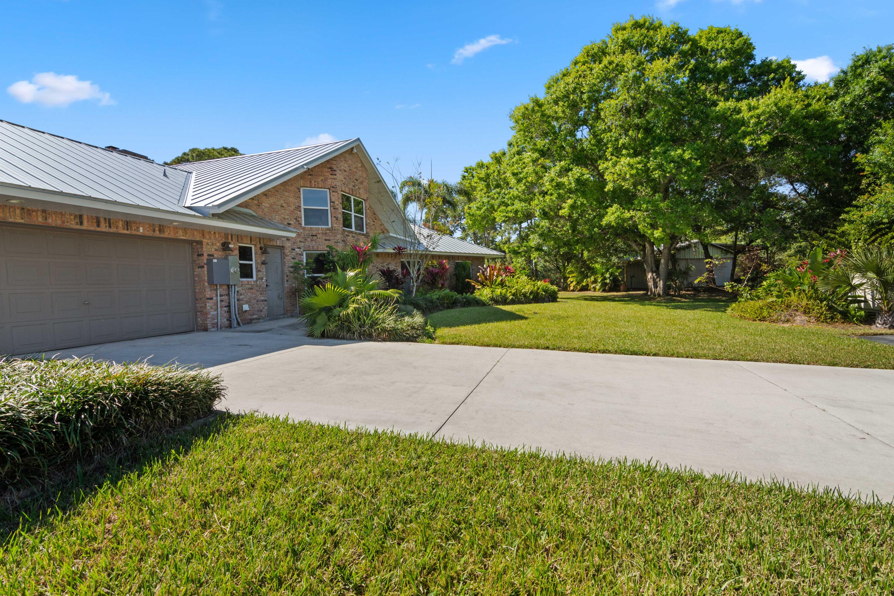 8850 Hidden Pines Road Fort Pierce, FL 34945 - Photo 8 of 72 a front view of a house with a yard and garage