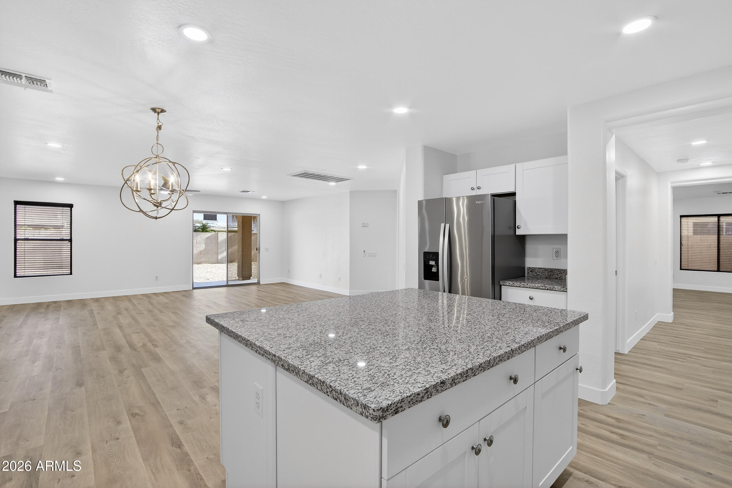 43620 West Cowpath Road Maricopa, AZ 85138 - Photo 19 of 60 a kitchen with stainless steel appliances granite countertop a kitchen island a cabinets and wooden floor