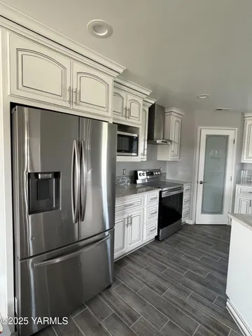 a kitchen with stainless steel appliances granite countertop a refrigerator and a stove top oven