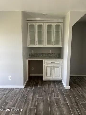 a view of kitchen with granite countertop white cabinets and sink