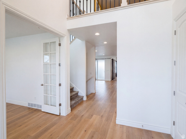 1251 North 2525 West Clinton, UT 84015 - Photo 7 of 30 Foyer featuring wood-finish flooring, a white paneled door, and a staircase with a wrought iron railing