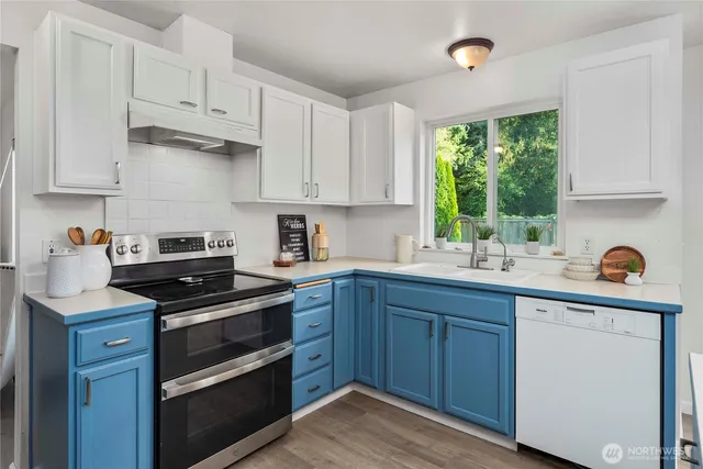a kitchen with granite countertop a stove sink and cabinets