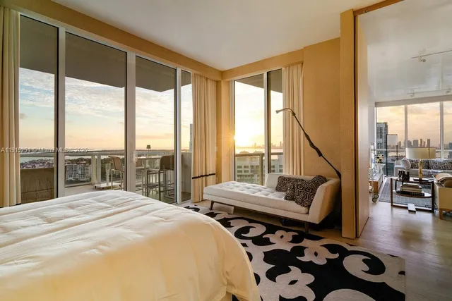 a bedroom with a bed and a view of balcony with couch