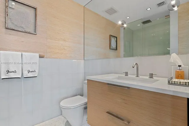 a bathroom with a granite countertop toilet sink and mirror