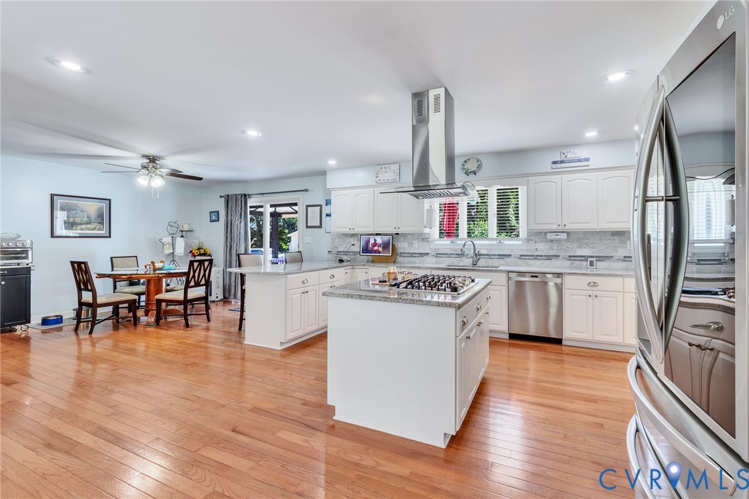 4400 Hacks Neck Road Heathsville, VA 22473 - Photo 13 of 78 a kitchen with kitchen island granite countertop wooden floors and stainless steel appliances
