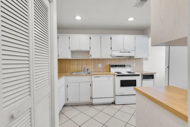 a kitchen with white cabinets and white appliances