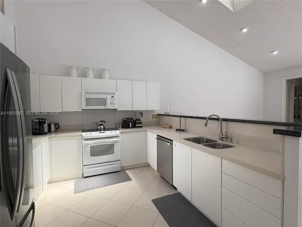 a kitchen with a sink stove and white cabinets