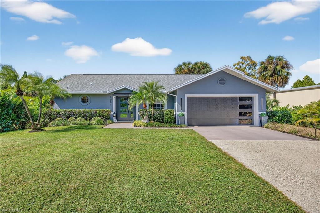 1081 9th Street Southwest Naples, FL 34117 - Photo 2 of 40 Ranch-style home featuring stucco siding, driveway, a front lawn, and a garage