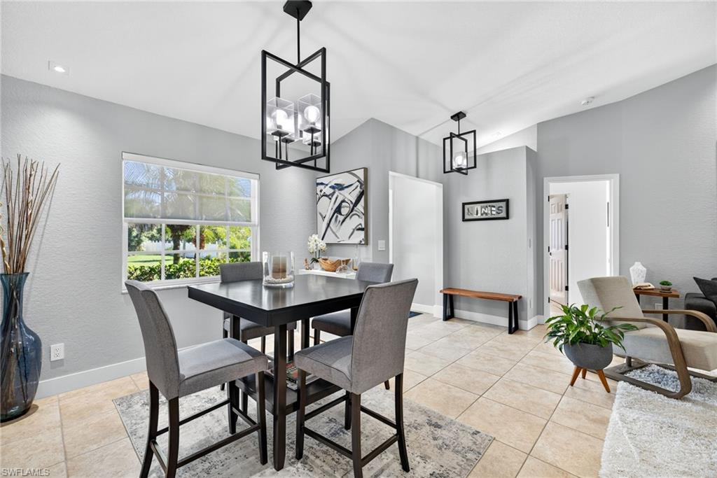 1081 9th Street Southwest Naples, FL 34117 - Photo 8 of 40 Dining space with light tile patterned floors, a textured wall, and a chandelier