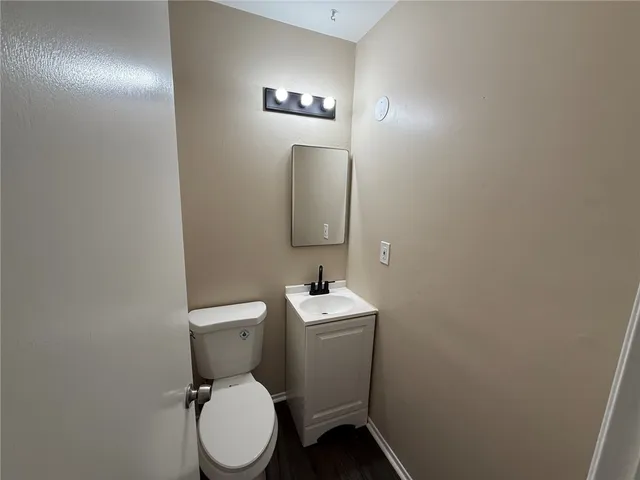 a bathroom with a toilet sink vanity and mirror