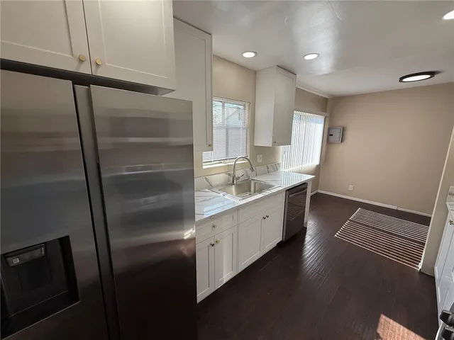 a kitchen with sink refrigerator and cabinets