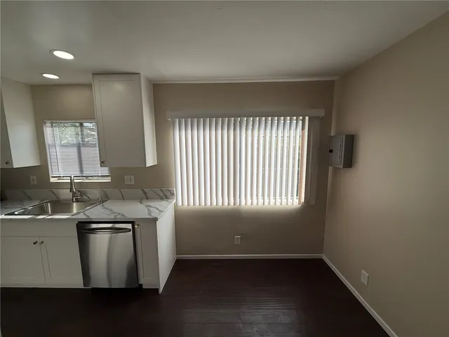 a kitchen with stainless steel appliances granite countertop a sink a stove a refrigerator and a window