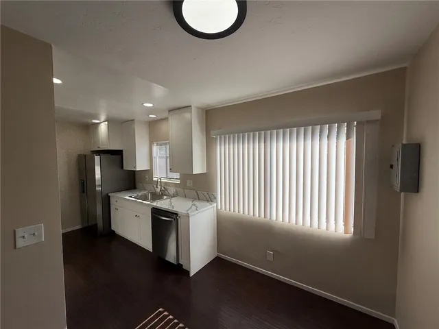 a kitchen with a sink cabinets and wooden floor