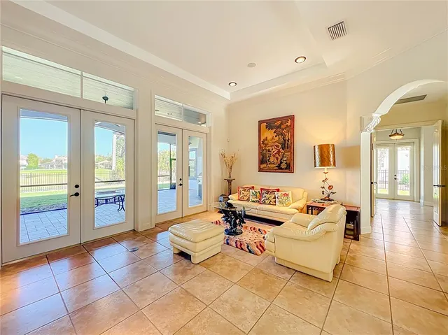 a view of a dining room and livingroom with furniture wooden floor a chandelier